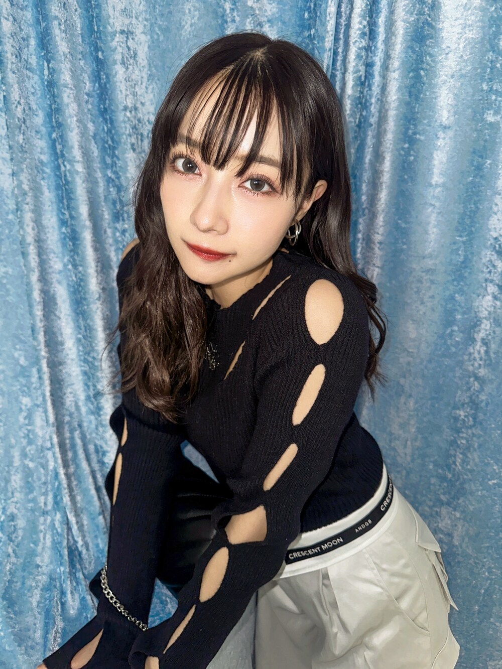 ブラック系のニット/セーター、グレー系のカーゴパンツ、ブラック系のショルダーバッグを着用したレディースの春コーディネートの2枚目の写真