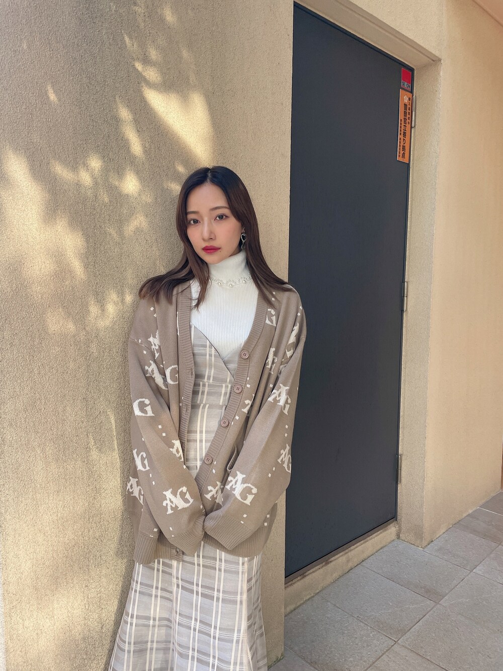 ホワイト系のニット/セーター、ベージュ系のワンピース、ブラウン系のカーディガン/ボレロを着用したレディースの春コーディネートの2枚目の写真