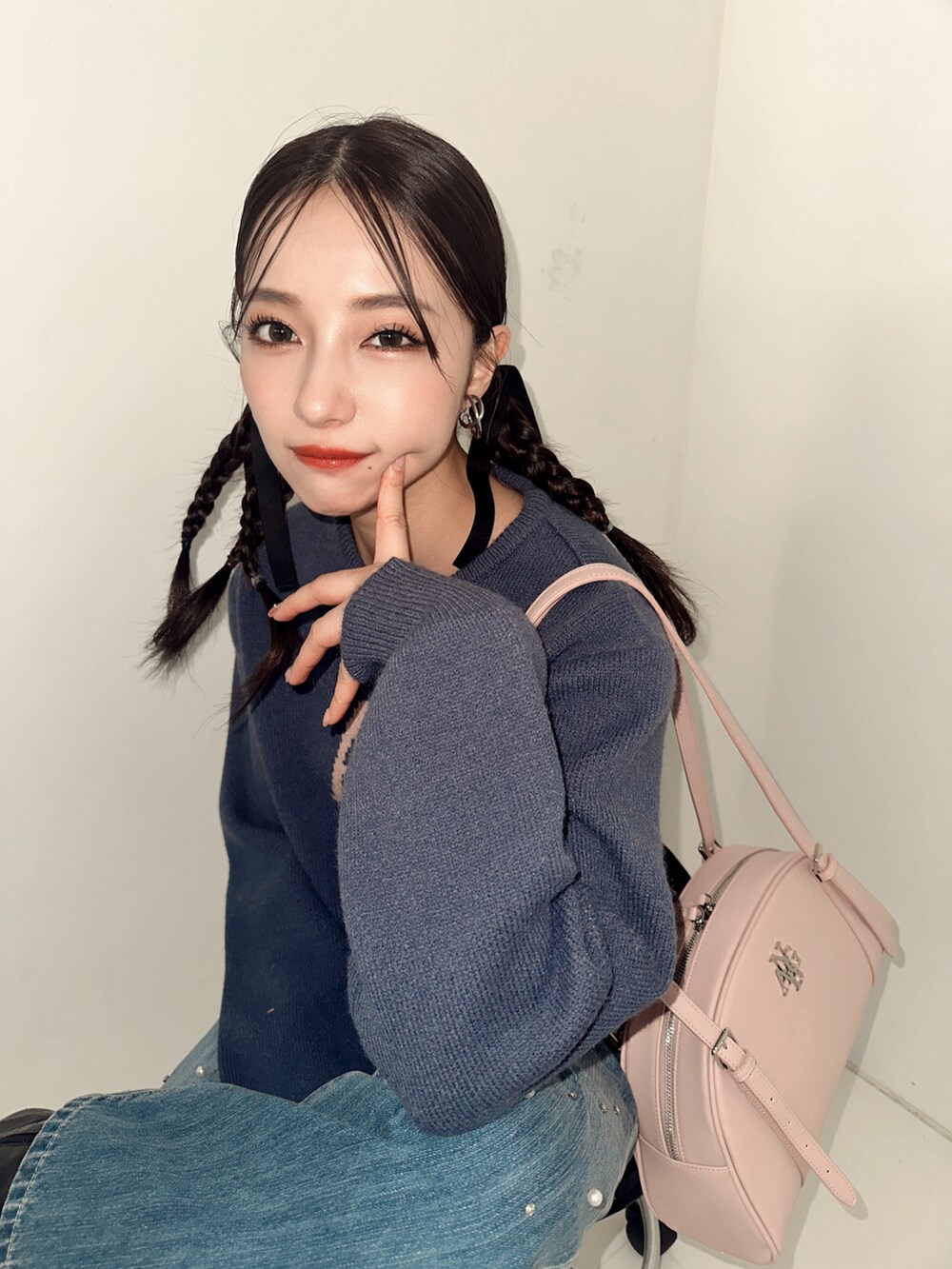 ブルー系のニット/セーター、ブラック系のショルダーバッグ、ブルー系のデニムパンツを着用したレディースの冬コーディネートの3枚目の写真