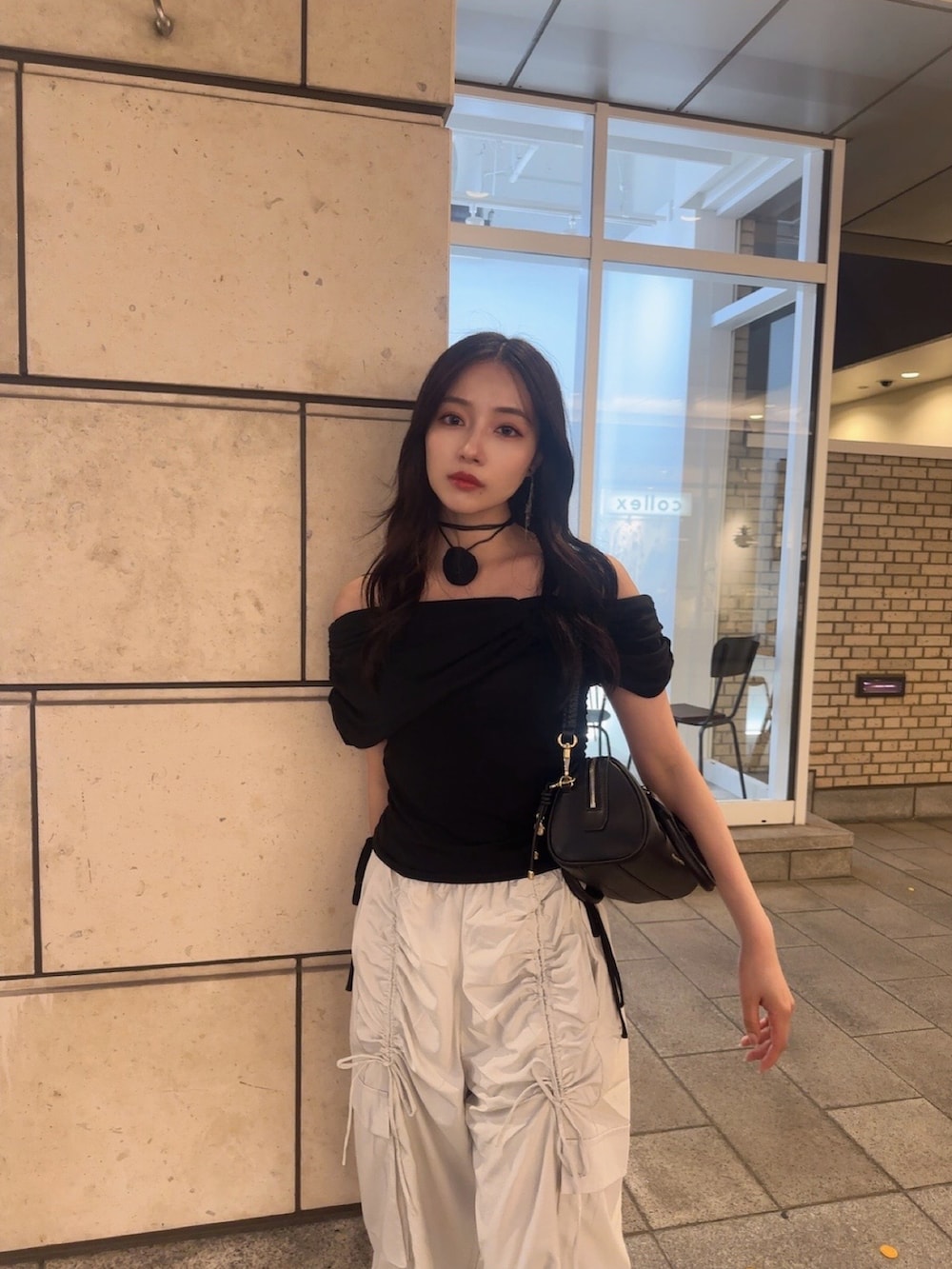 ブラック系のカーゴパンツ、ブラック系のTシャツ/カットソーを着用したレディースの秋コーディネートの2枚目の写真