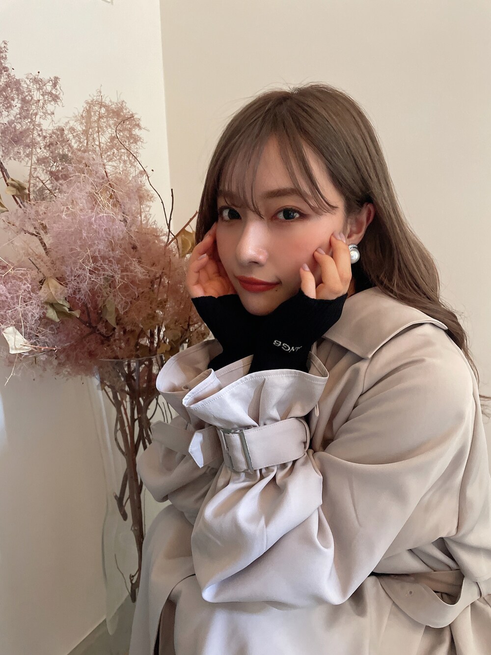 グレー系のトレンチコートを着用したレディースの秋コーディネートの2枚目の写真