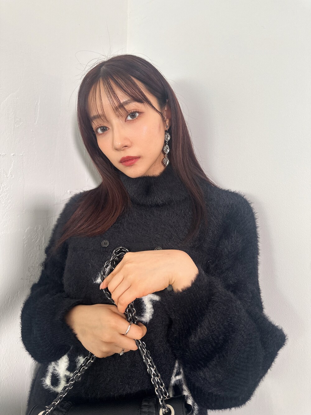 ブラック系のワンピース、ブルー系のショルダーバッグを着用したレディースの冬コーディネートの5枚目の写真