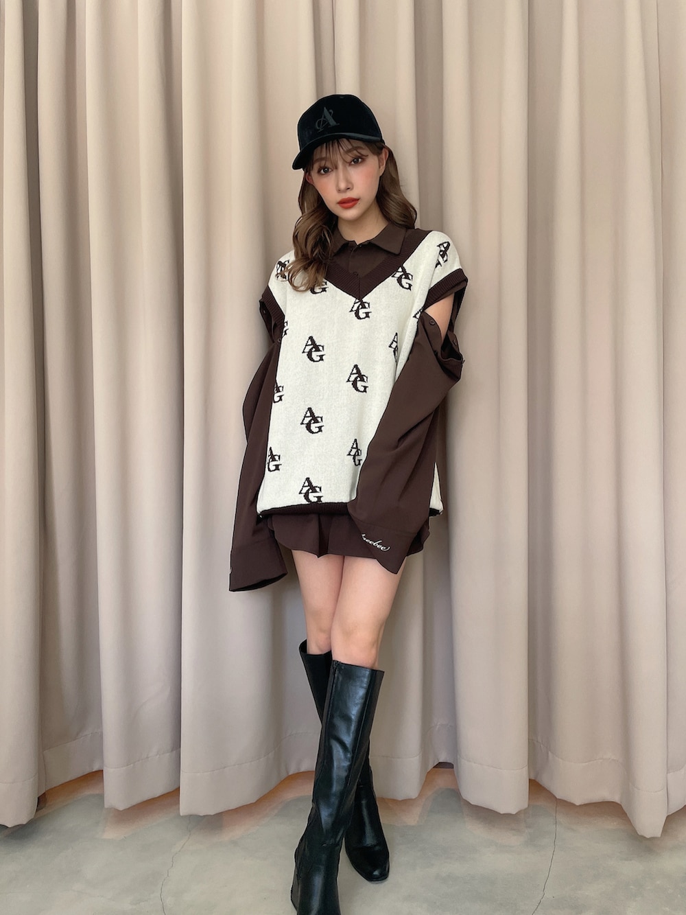 ブラウン系のシャツ/ブラウス、ホワイト系のベスト、ブラック系のキャップを着用したレディースの秋コーディネートの2枚目の写真