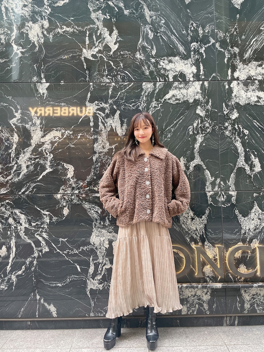 ブラウン系のダウンジャケット/コート、ブラック系のワンピースを着用したレディースの冬コーディネートの2枚目の写真