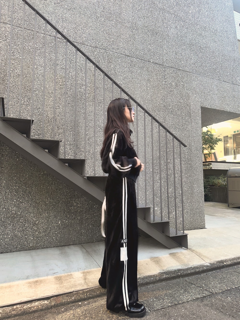 ブラック系のジャージ、ホワイト系のバックパック/リュックを着用したレディースの冬コーディネートの2枚目の写真