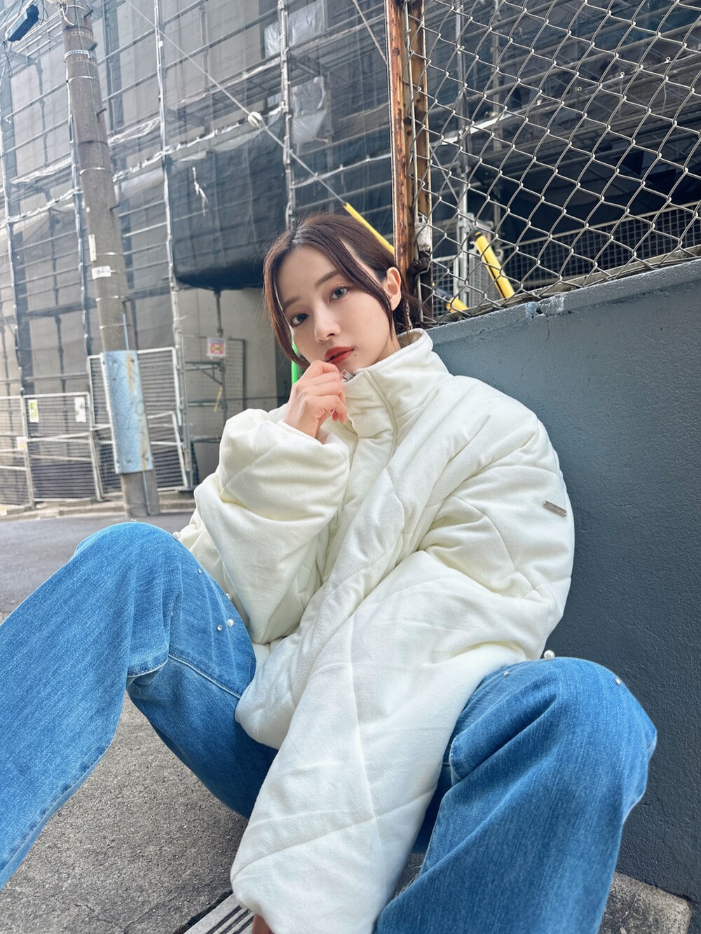 ホワイト系のダウンジャケット/コート、ブルー系のデニムパンツを着用したレディースの冬コーディネートの3枚目の写真