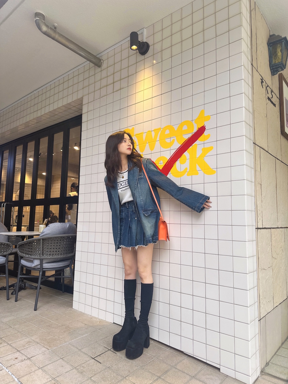 ブルー系のニット/セーター、ブルー系のデニムジャケット、ブルー系のスカートを着用したレディースの夏コーディネートの3枚目の写真