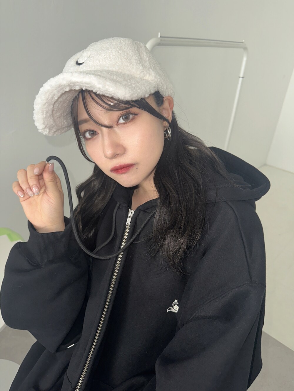 ブラック系のパーカー、ホワイト系のキャップを着用したレディースの秋コーディネートの5枚目の写真