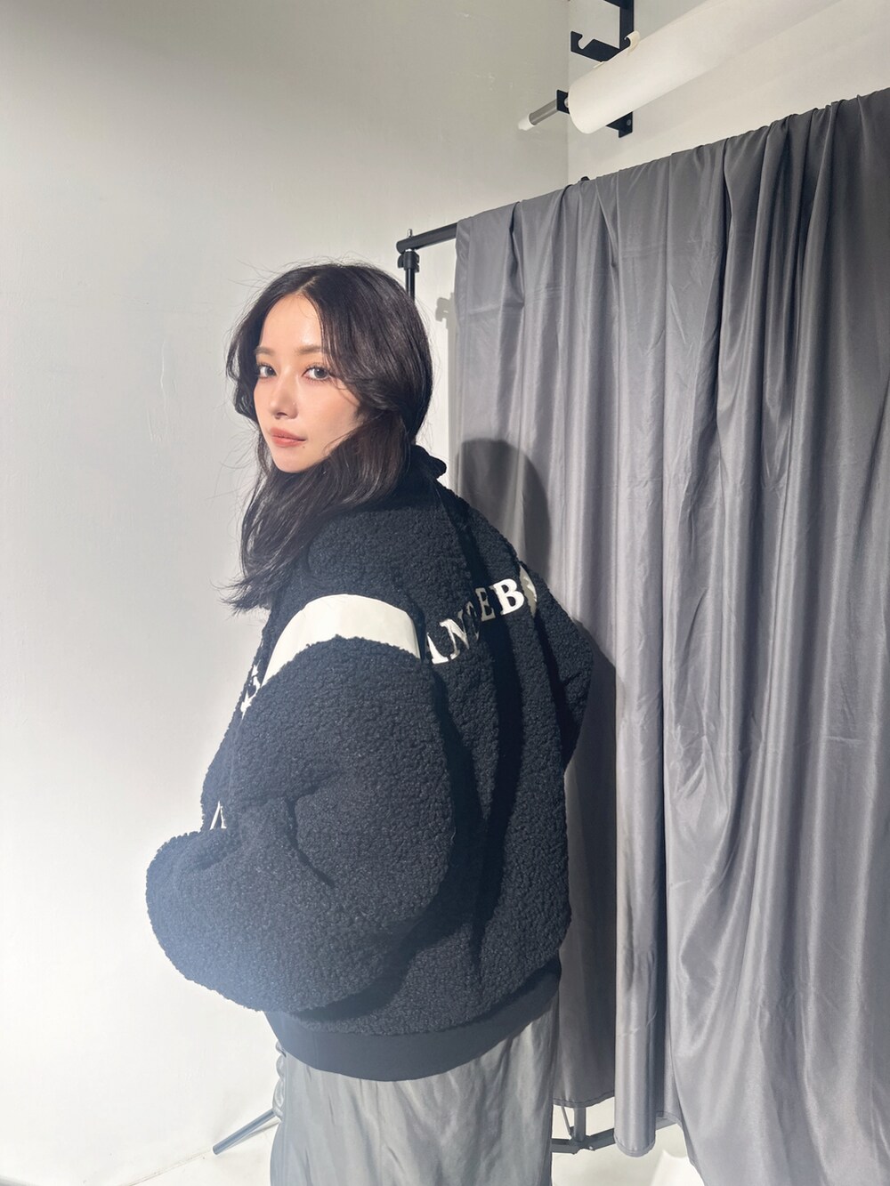 ブラック系のスタジャン、グレー系のスカートを着用したレディースの冬コーディネートの3枚目の写真