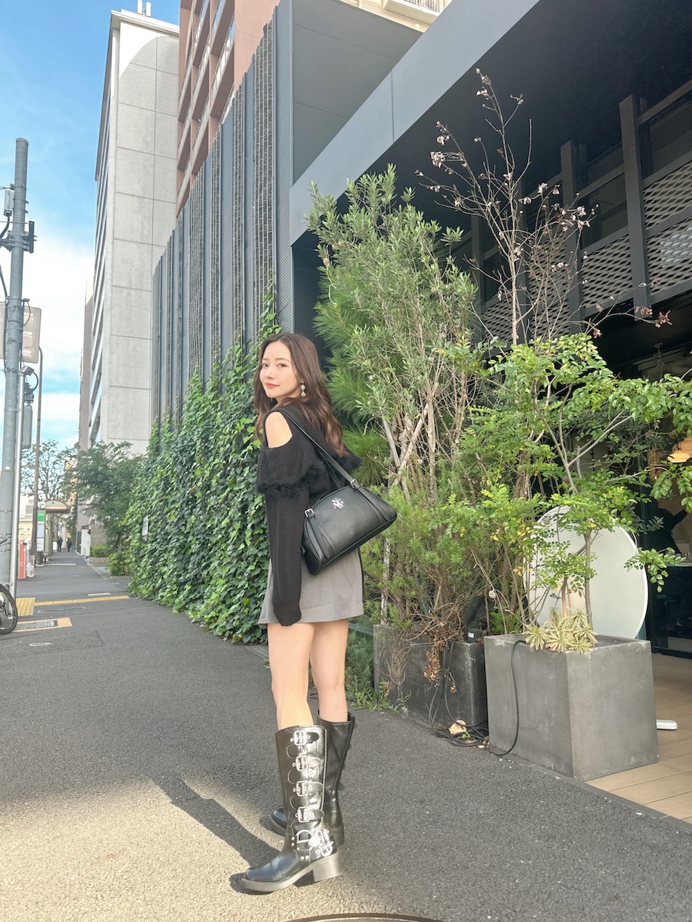 ブラック系のニット/セーター、ブラック系のショルダーバッグを着用したレディースの春コーディネートの3枚目の写真