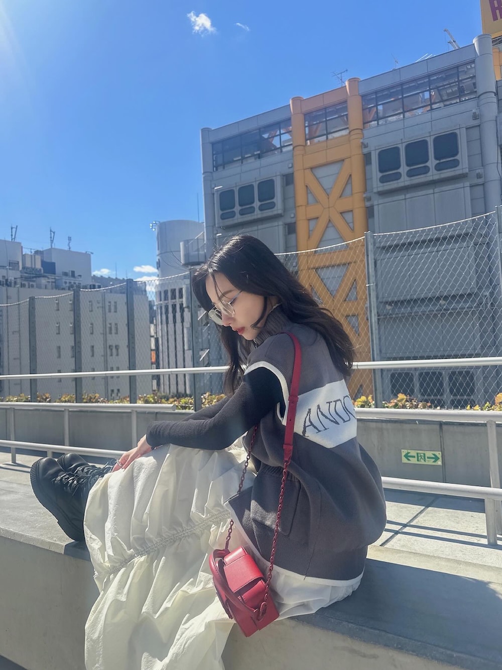 グレー系のベスト、ホワイト系のスカートを着用したレディースの夏コーディネートの3枚目の写真