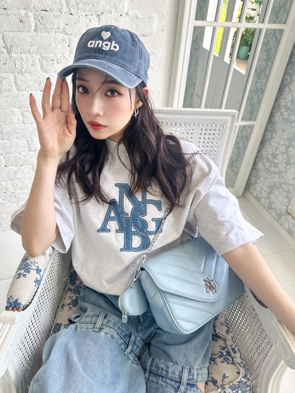 ブルー系のショルダーバッグ、グレー系のTシャツ/カットソー、ブルー系のキャップを着用したレディースの夏コーディネートの4枚目の写真