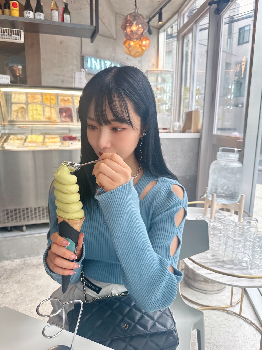 ブルー系のニット/セーター、グレー系のカーゴパンツを着用したレディースの春コーディネートの3枚目の写真