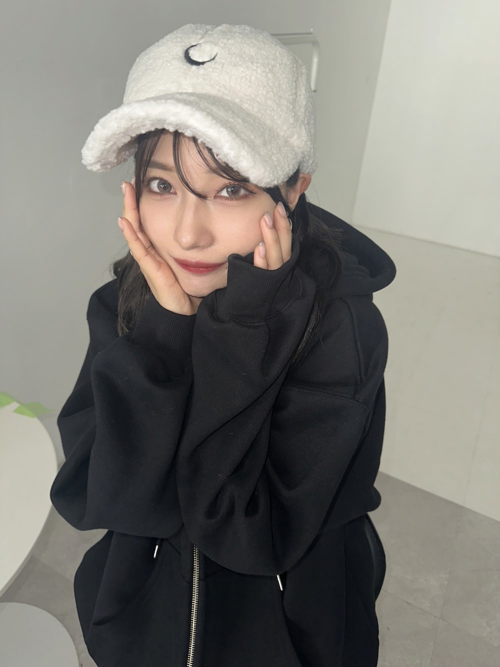 ブラック系のパーカー、ホワイト系のキャップを着用したレディースの秋コーディネートの3枚目の写真