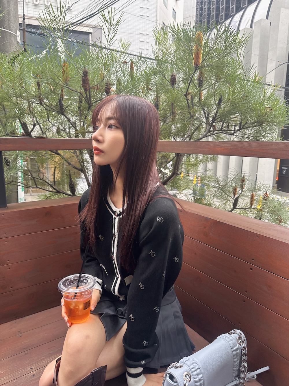 ブラック系のアンサンブル、ブルー系のショルダーバッグを着用したレディースの冬コーディネートの3枚目の写真