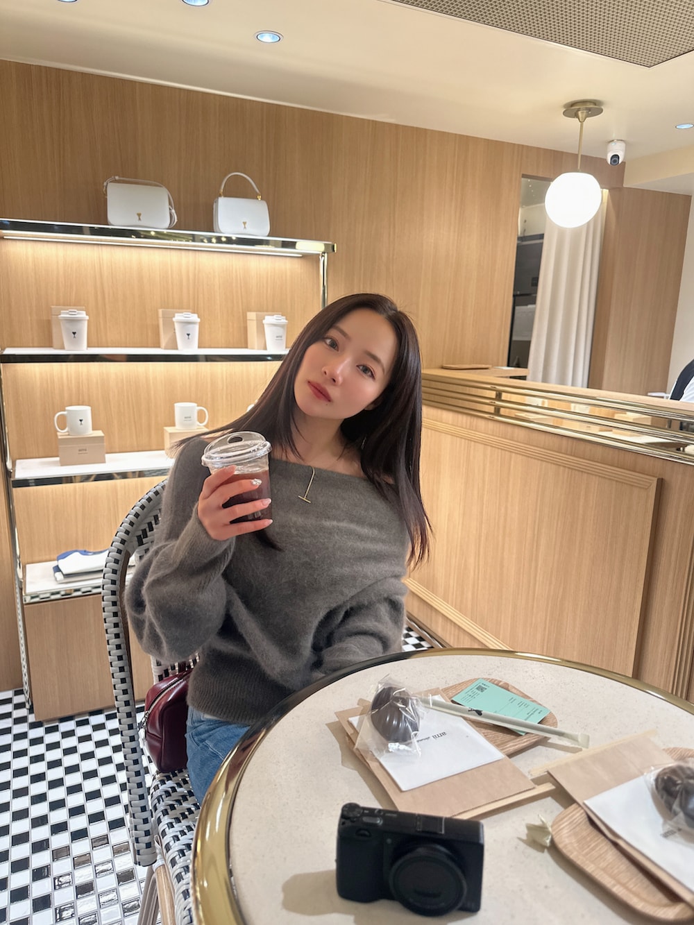 ブラウン系のニット/セーターを着用したレディースの春コーディネートの2枚目の写真