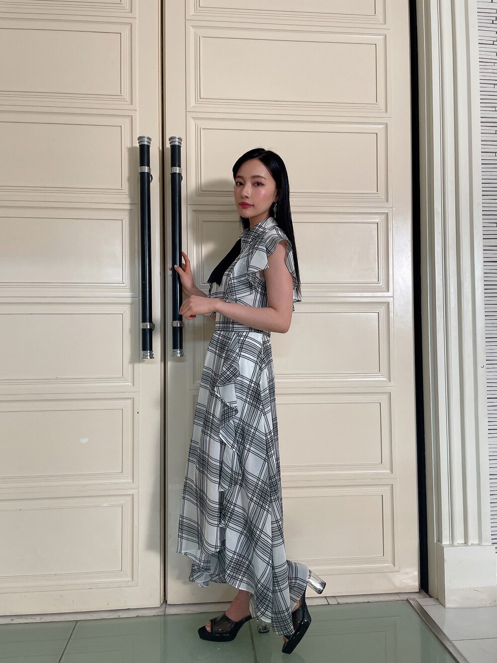 ホワイト系のシャツ/ブラウス、ホワイト系のスカート、ブラック系のサンダルを着用したレディースの春コーディネートの2枚目の写真