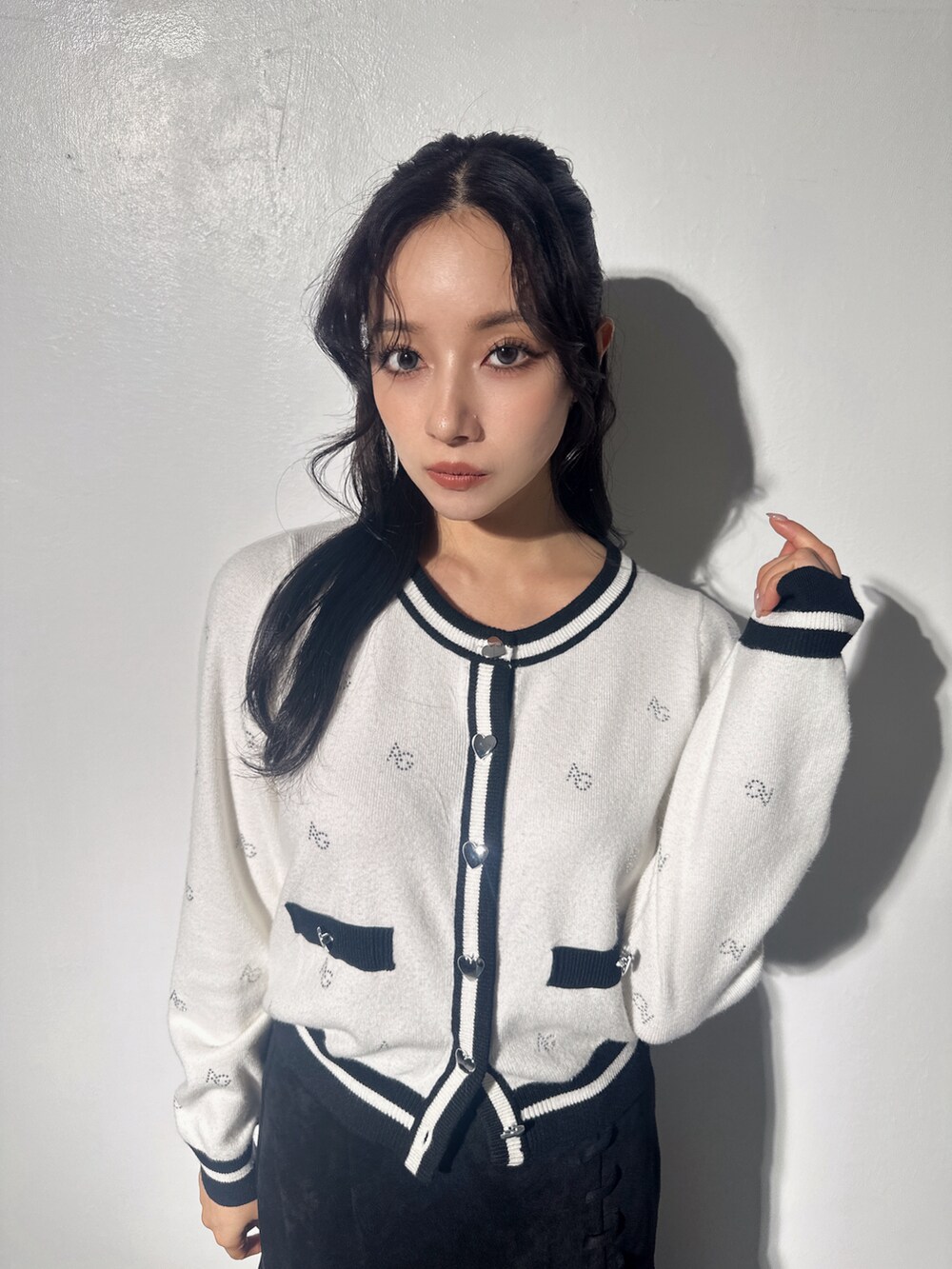 ホワイト系のアンサンブル、ブラック系のスカートを着用したレディースの冬コーディネートの4枚目の写真