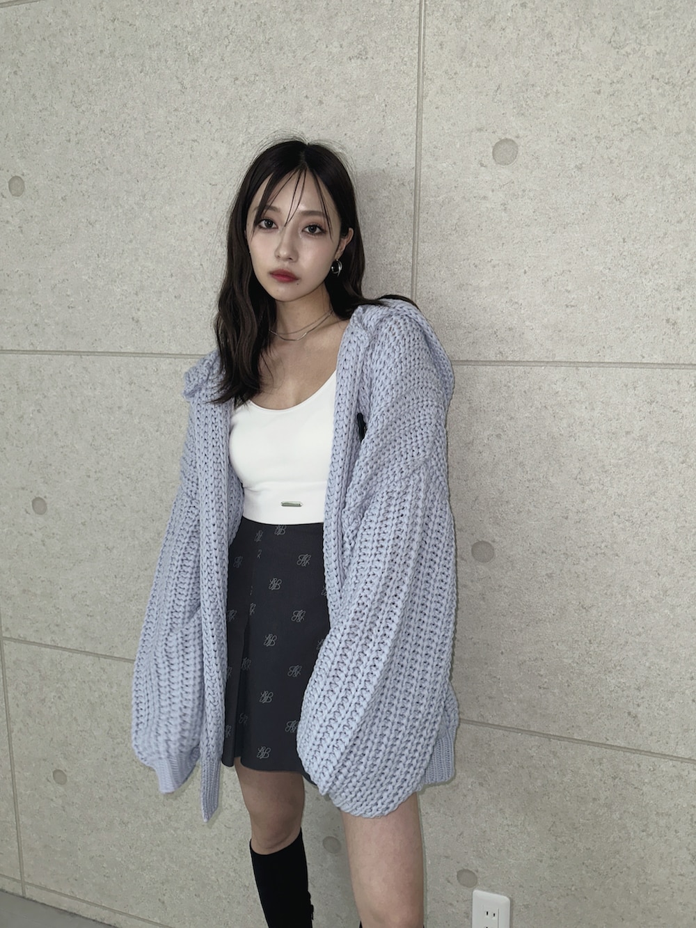 グレー系のスカート、ブルー系のニット/セーターを着用したレディースの秋コーディネートの2枚目の写真