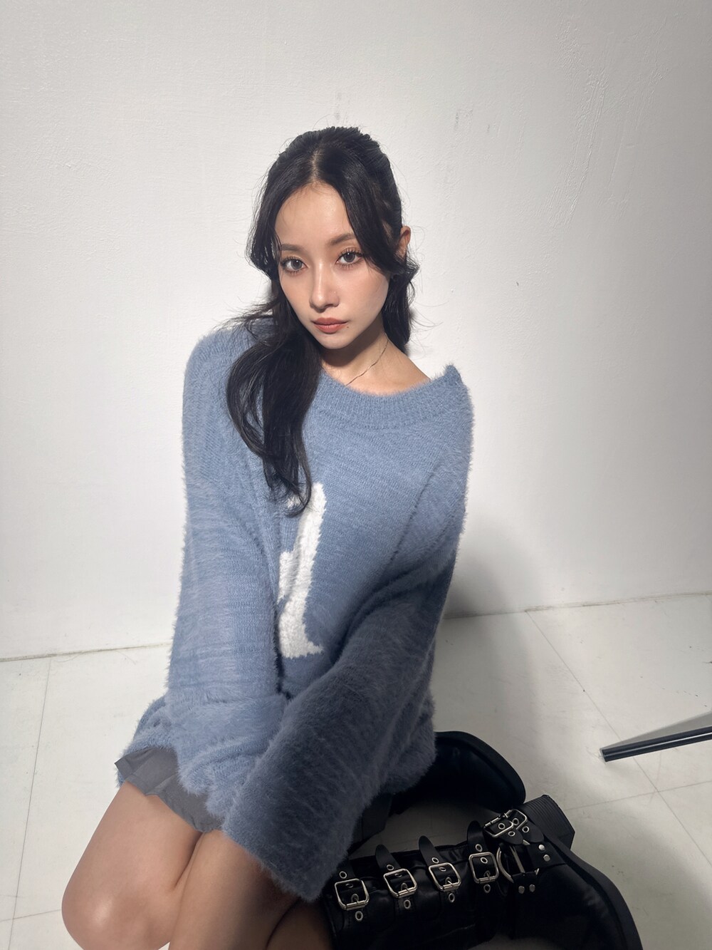 ブルー系のニット/セーター、グレー系のスカートを着用したレディースの冬コーディネートの4枚目の写真