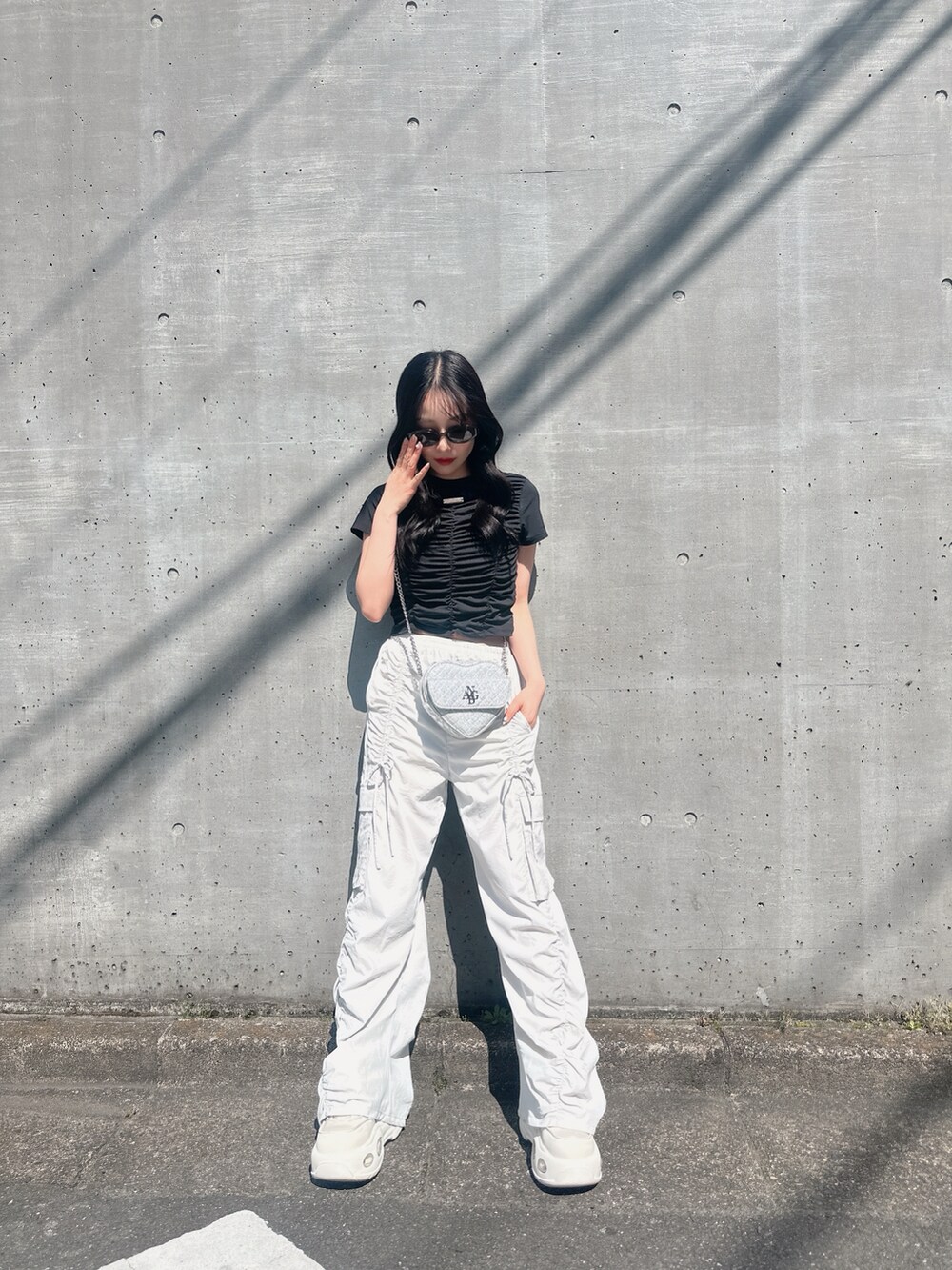 ブラック系のTシャツ/カットソー、ベージュ系のカーゴパンツ、ホワイト系のスニーカーを着用したレディースの夏コーディネートの3枚目の写真