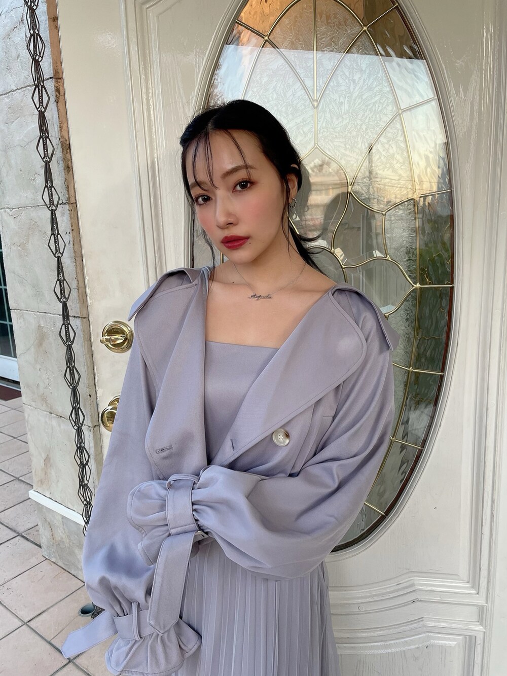 グレー系のトレンチコート、グレー系のワンピースを着用したレディースの夏コーディネートの2枚目の写真