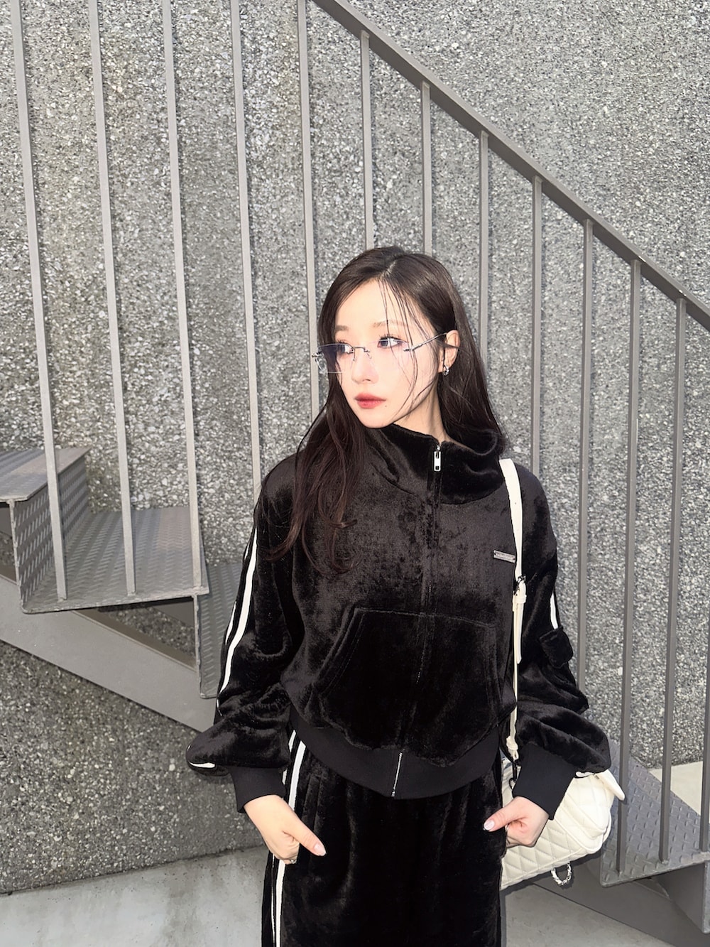 ブラック系のジャージ、ホワイト系のバックパック/リュックを着用したレディースの冬コーディネートの3枚目の写真