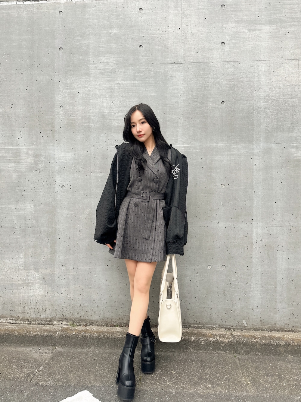 ブラック系のワンピース、ブラック系のトートバッグ、ブラック系のパーカーを着用したレディースの春コーディネートの3枚目の写真