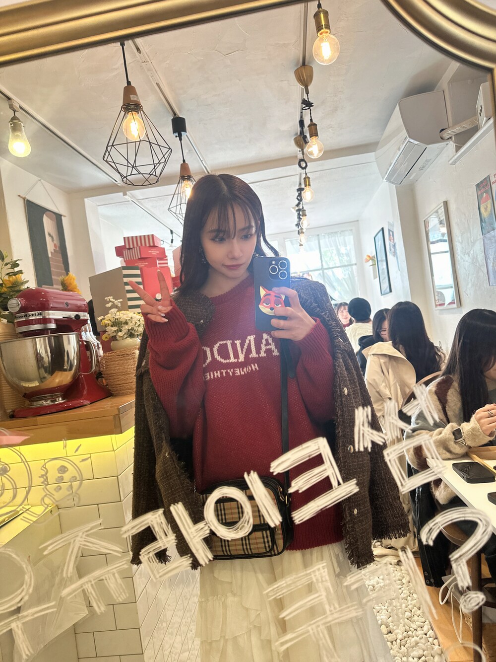 レッド系のニット/セーター、ブラウン系のその他アウターを着用したレディースの冬コーディネートの2枚目の写真