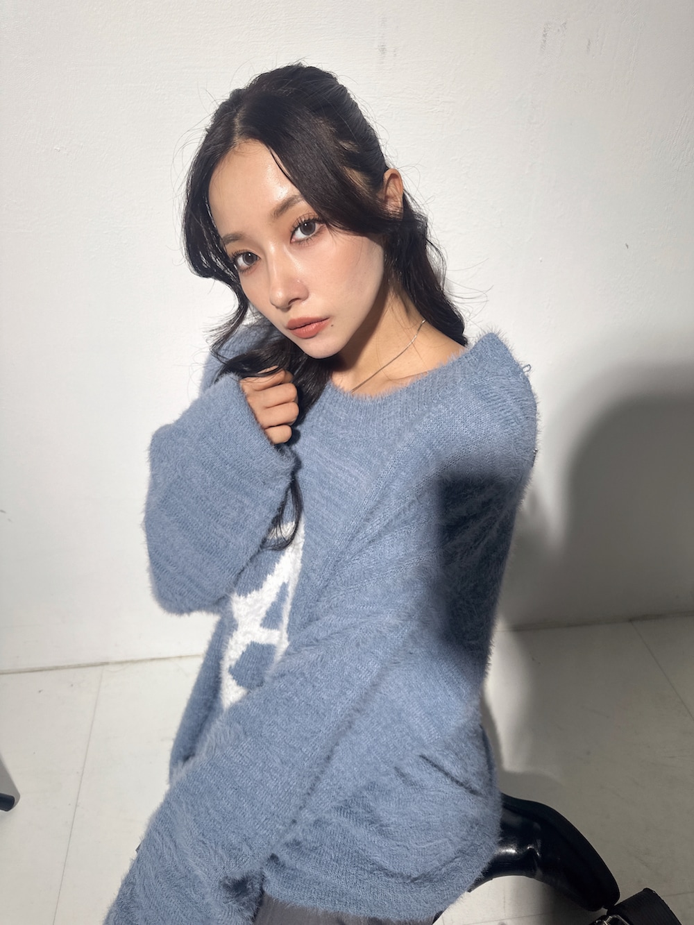 ブルー系のニット/セーター、グレー系のスカートを着用したレディースの冬コーディネートの5枚目の写真