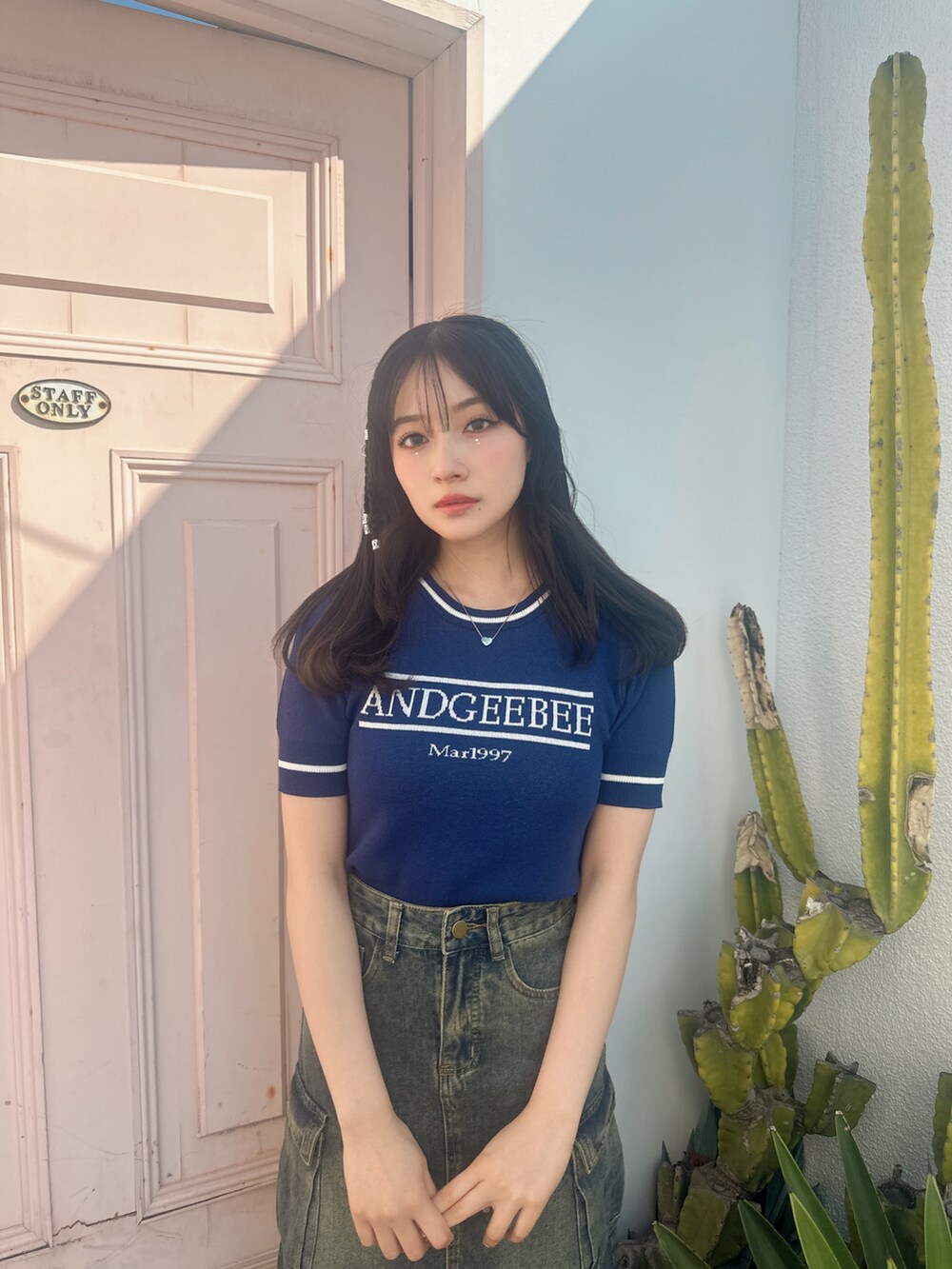 ブルー系のニット/セーターを着用したレディースの夏コーディネートの2枚目の写真