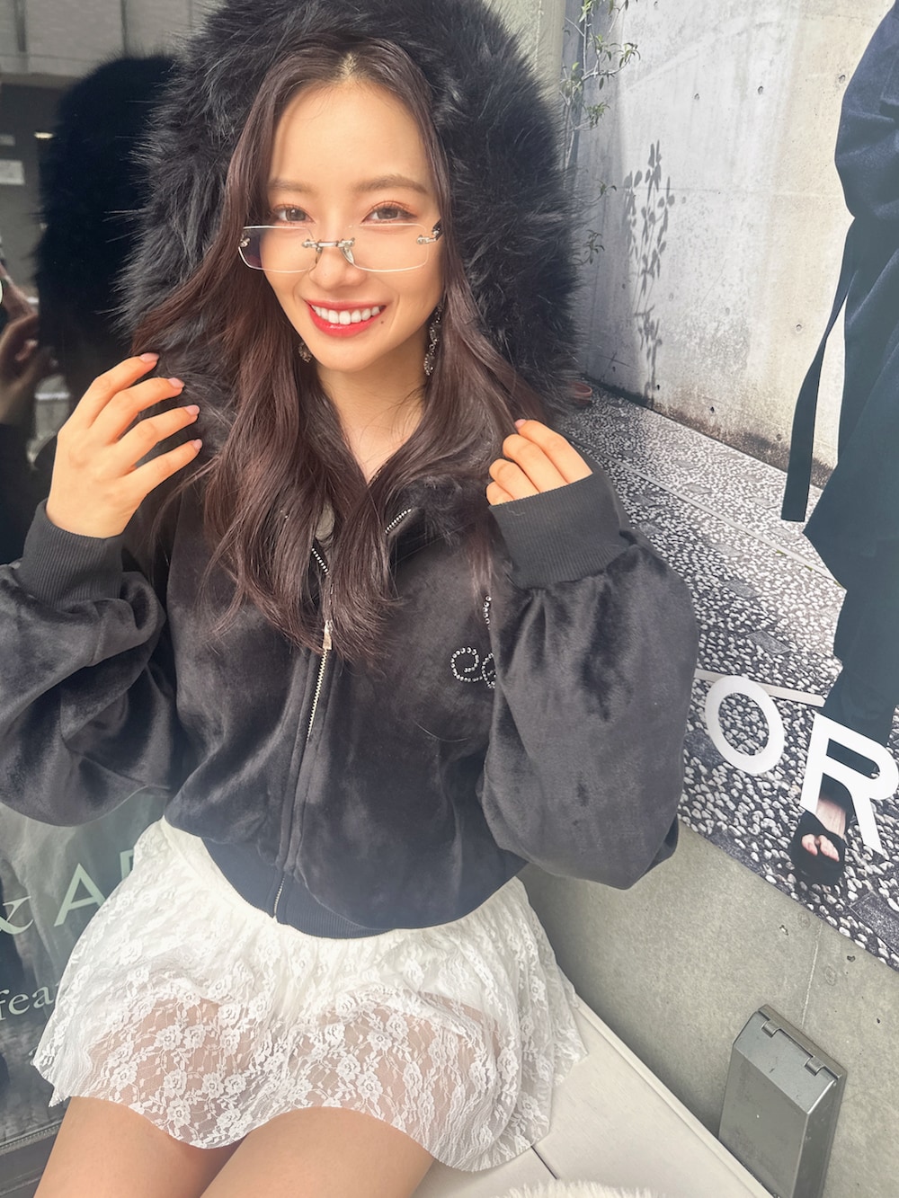 ブラック系のパーカー、ホワイト系のショルダーバッグを着用したレディースの冬コーディネートの3枚目の写真