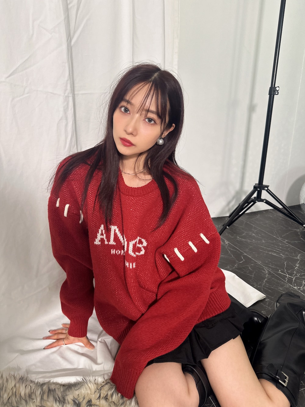 レッド系のニット/セーターを着用したレディースの冬コーディネートの3枚目の写真