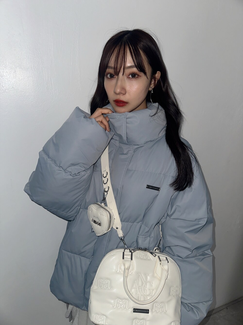 ホワイト系のスカート、グレー系のショルダーバッグ、ブルー系のダウンジャケット/コートを着用したレディースの春コーディネートの4枚目の写真