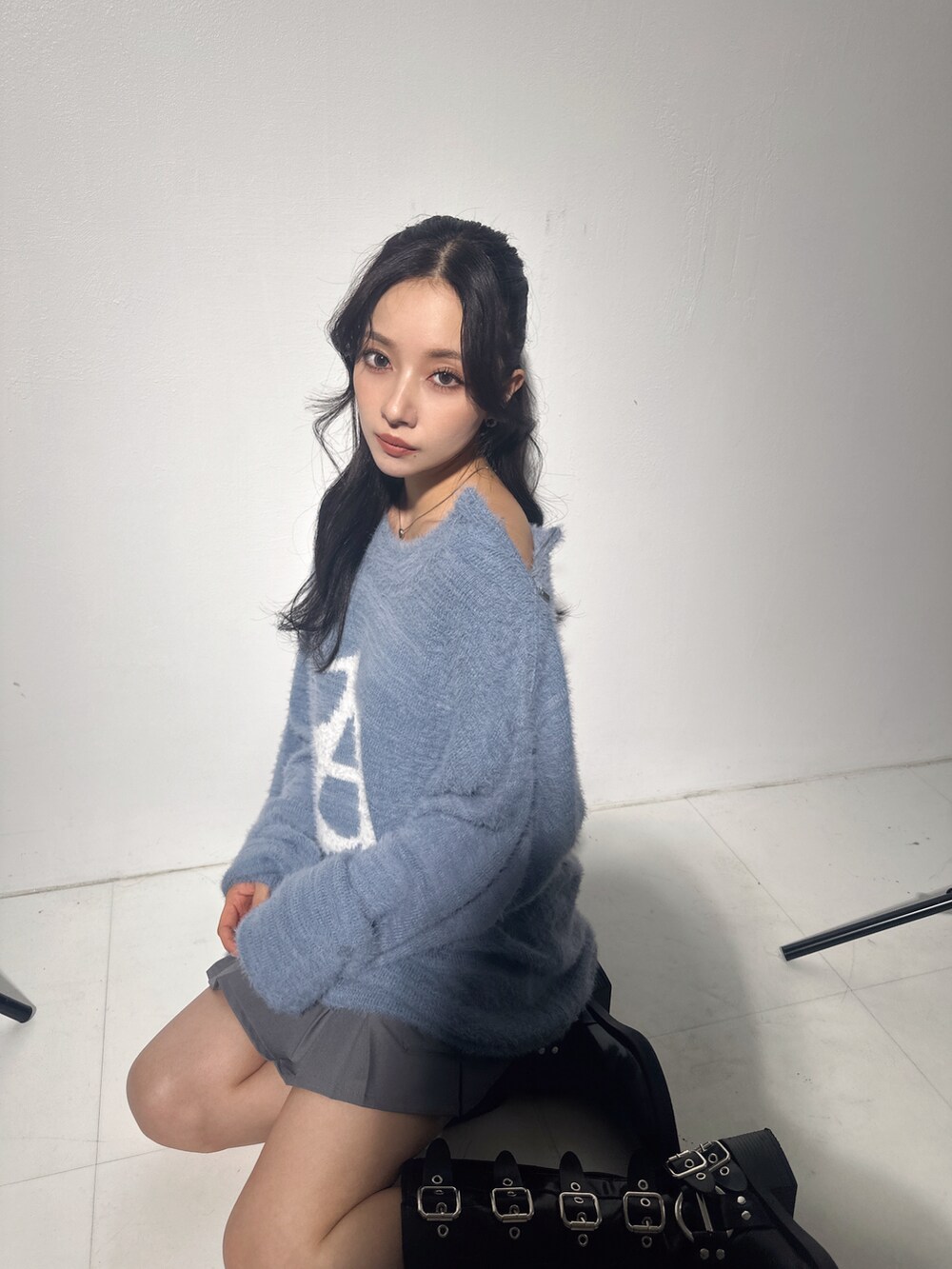 ブルー系のニット/セーター、グレー系のスカートを着用したレディースの冬コーディネートの3枚目の写真