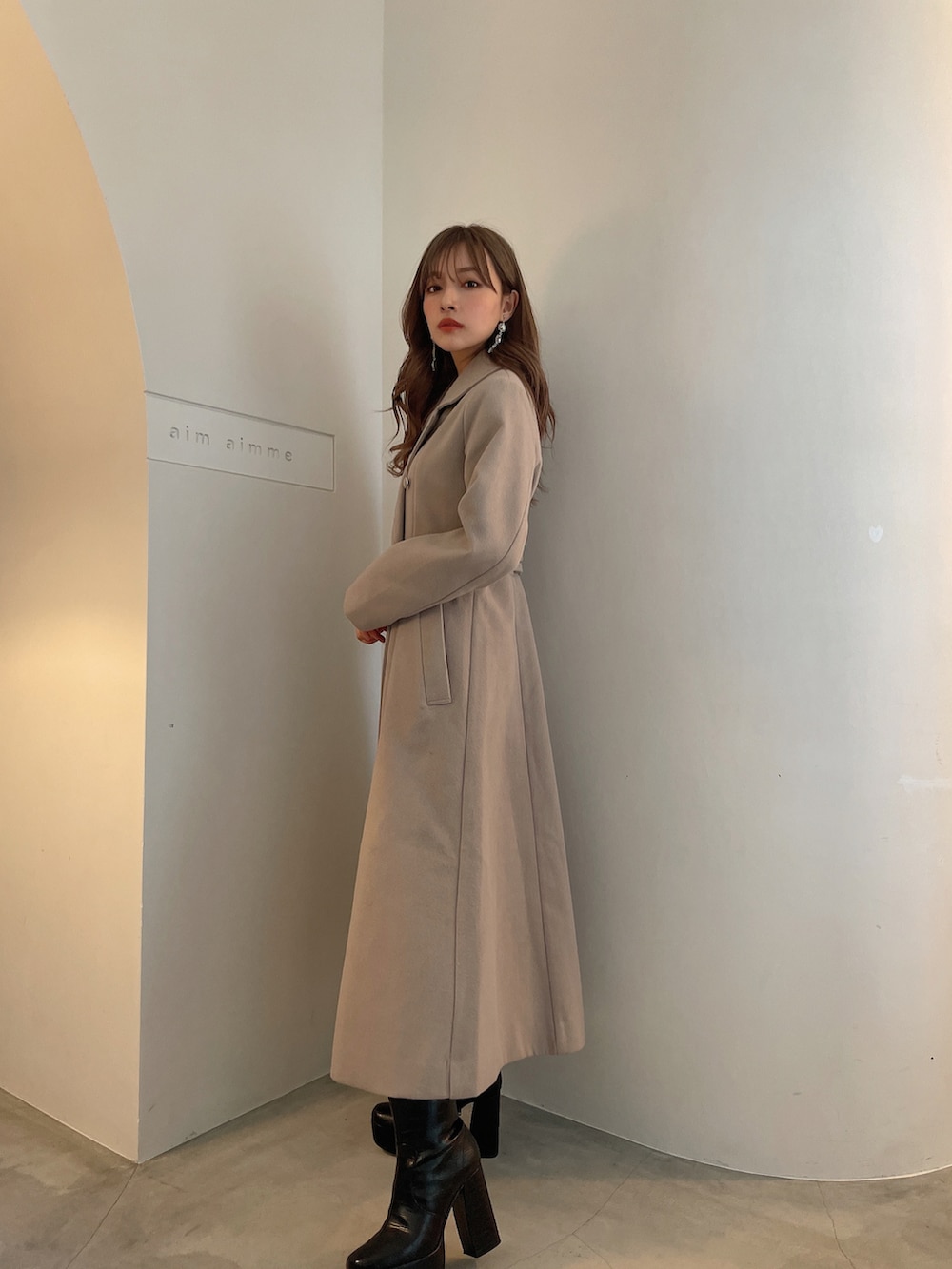 グレー系のチェスターコートを着用したレディースの冬コーディネートの2枚目の写真