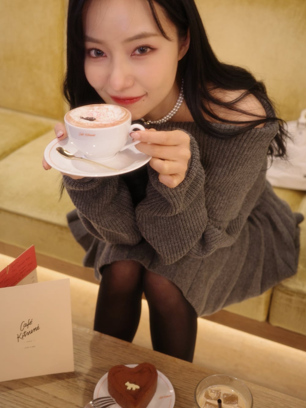 グレー系のワンピース、ブラック系のショルダーバッグを着用したレディースの春コーディネートの3枚目の写真