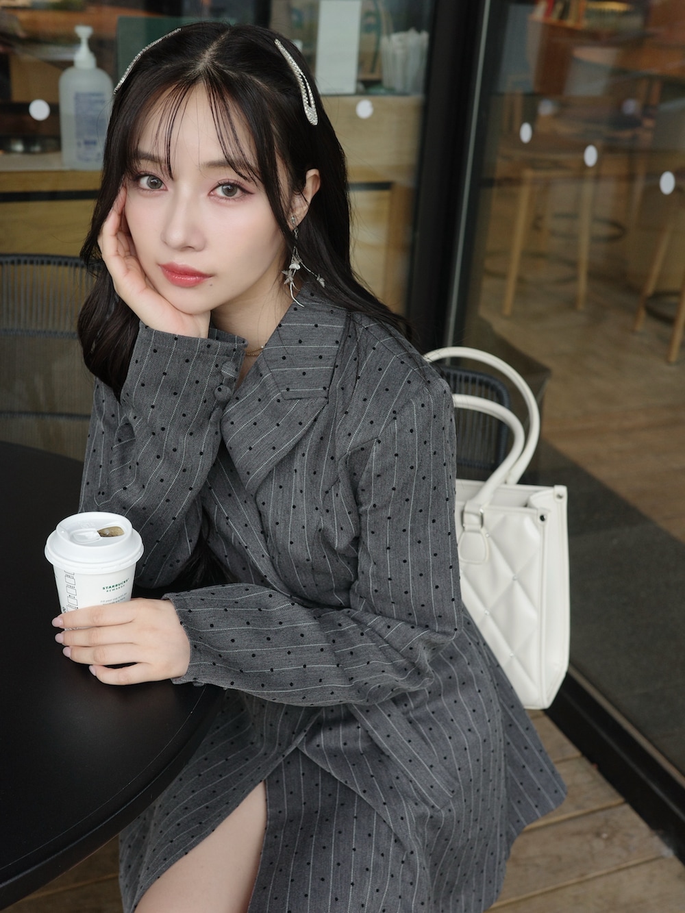 ブラック系のワンピース、ホワイト系のトートバッグを着用したレディースの冬コーディネートの2枚目の写真