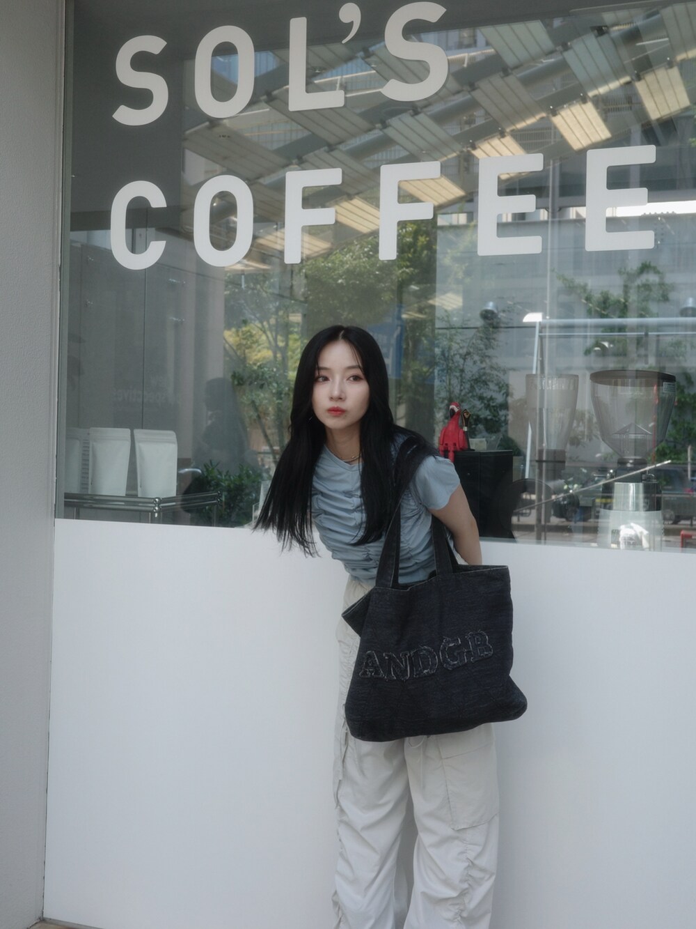 ブラック系のトートバッグ、ベージュ系のカーゴパンツ、ブルー系のTシャツ/カットソーを着用したレディースの秋コーディネートの3枚目の写真