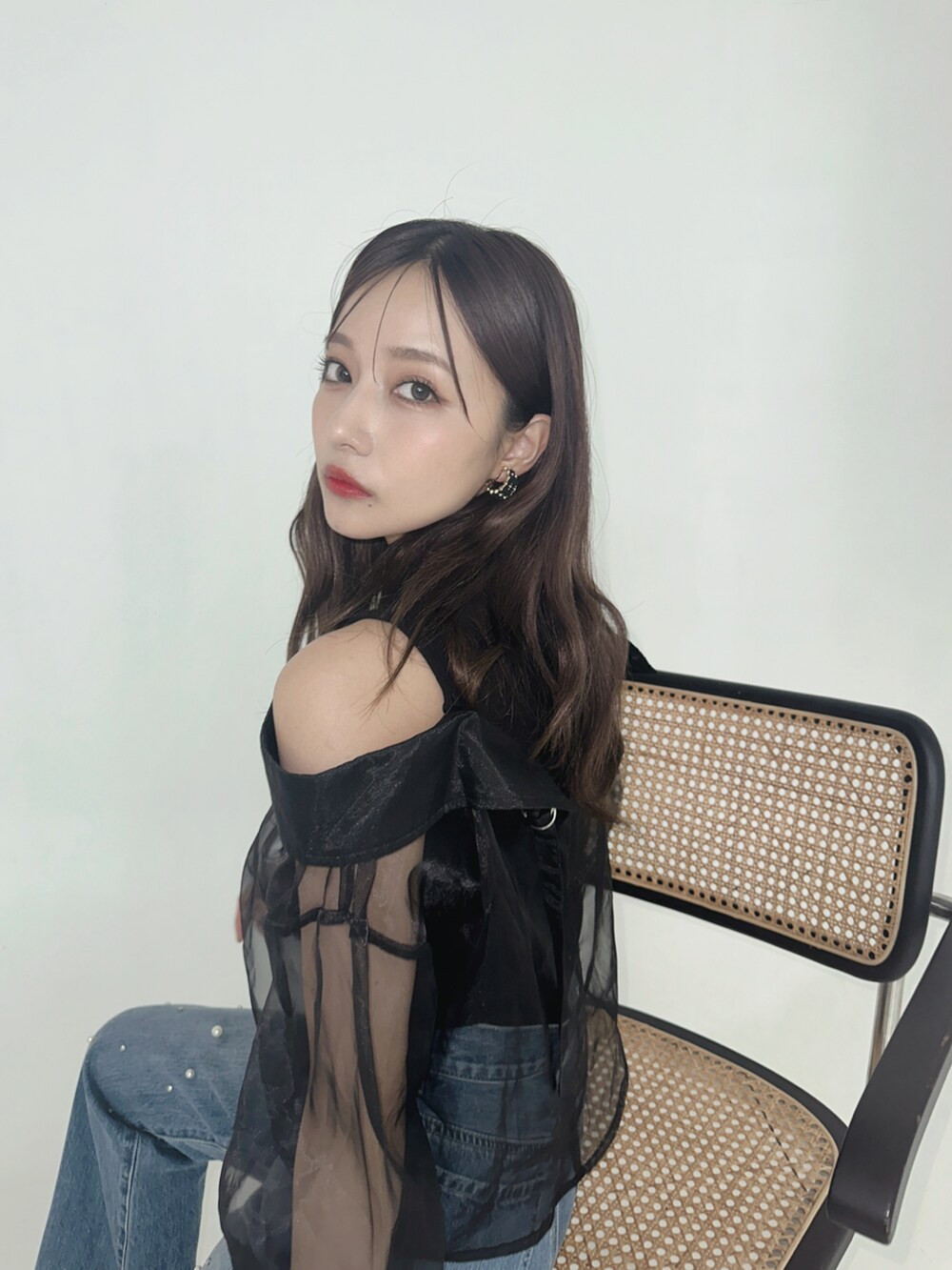 ブラック系のその他トップス、ブルー系のデニムパンツを着用したレディースの秋コーディネートの2枚目の写真