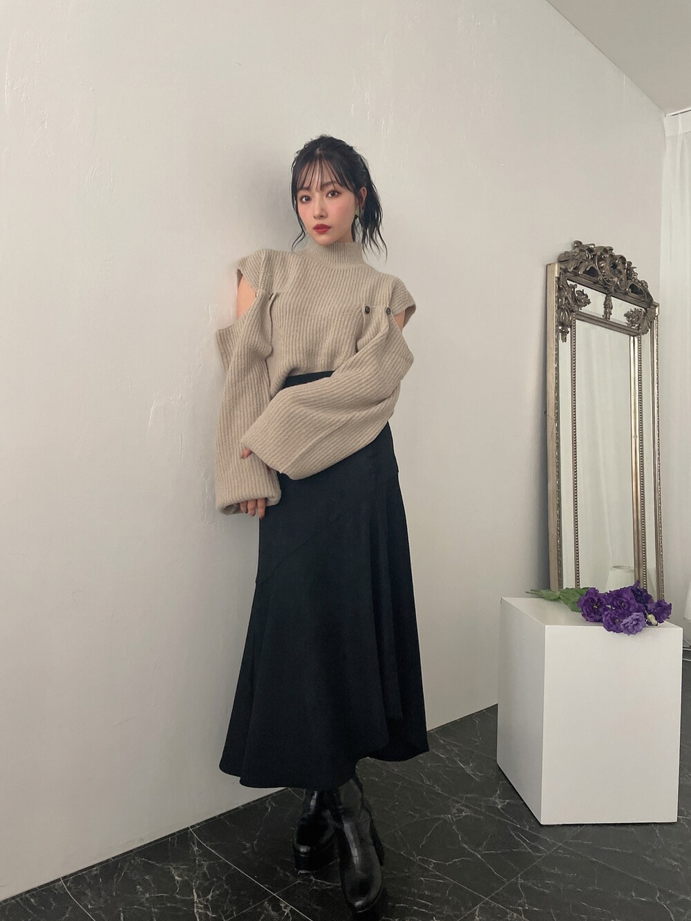グリーン系のニット/セーター、ブラック系のスカートを着用したレディースの冬コーディネートの3枚目の写真