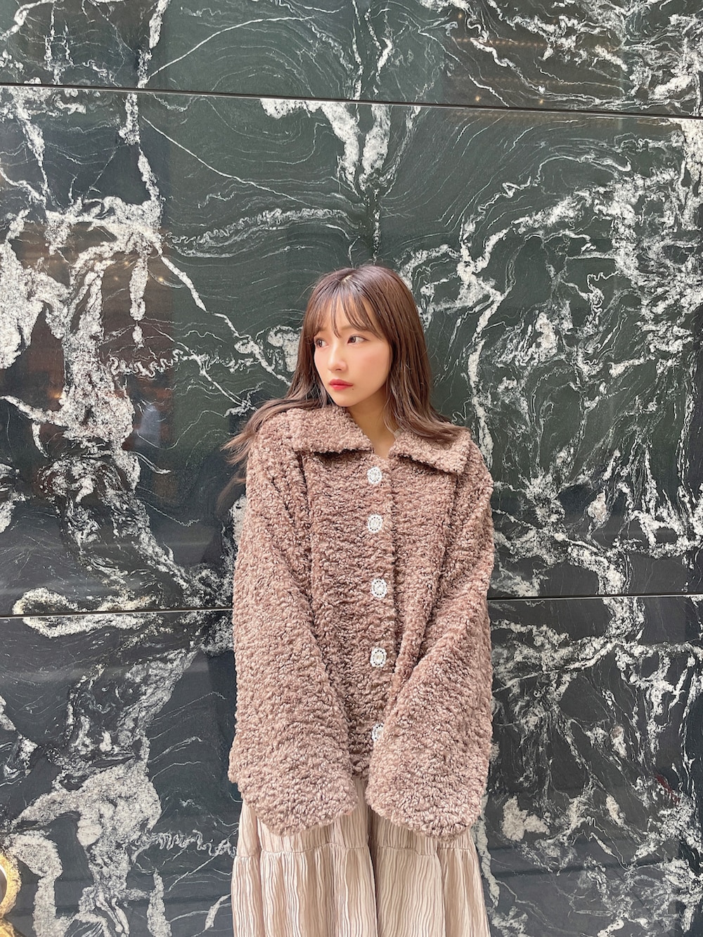 ブラウン系のダウンジャケット/コート、ブラック系のワンピースを着用したレディースの冬コーディネートの3枚目の写真