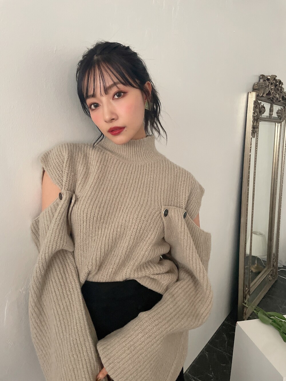 グリーン系のニット/セーター、ブラック系のスカートを着用したレディースの冬コーディネートの5枚目の写真