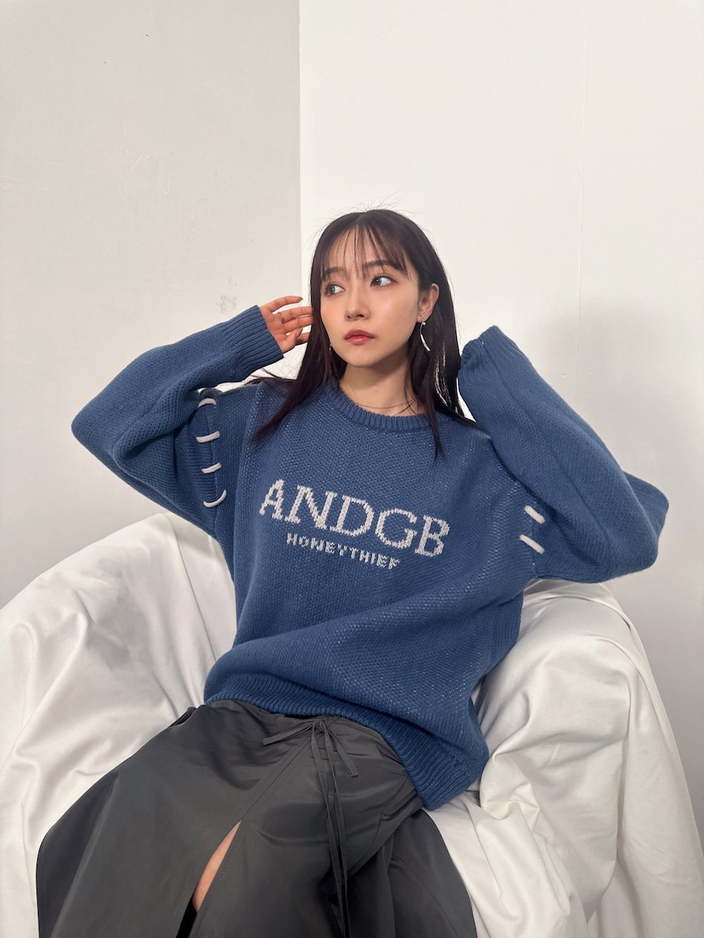 ブルー系のニット/セーター、グレー系のスカートを着用したレディースの冬コーディネートの2枚目の写真