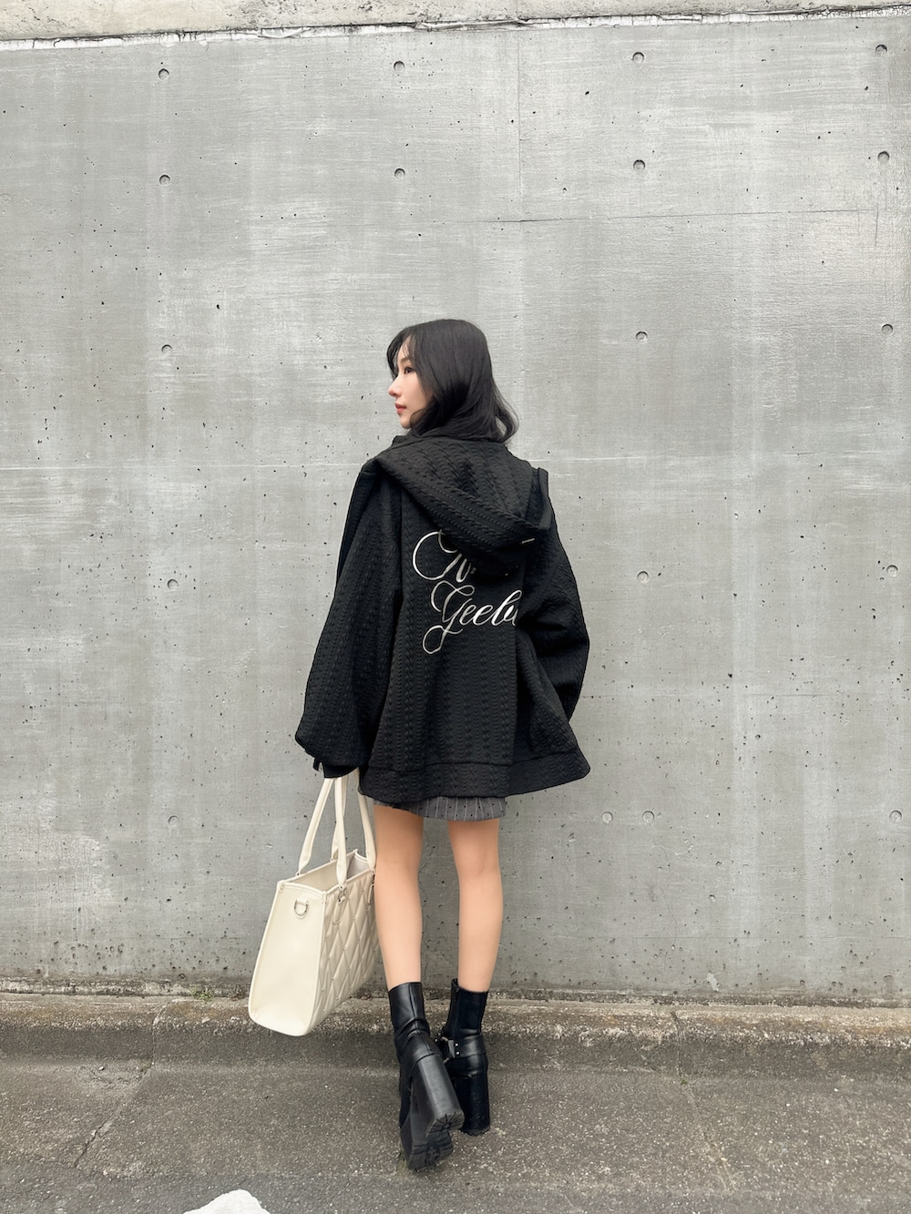 ブラック系のワンピース、ブラック系のトートバッグ、ブラック系のパーカーを着用したレディースの春コーディネートの2枚目の写真