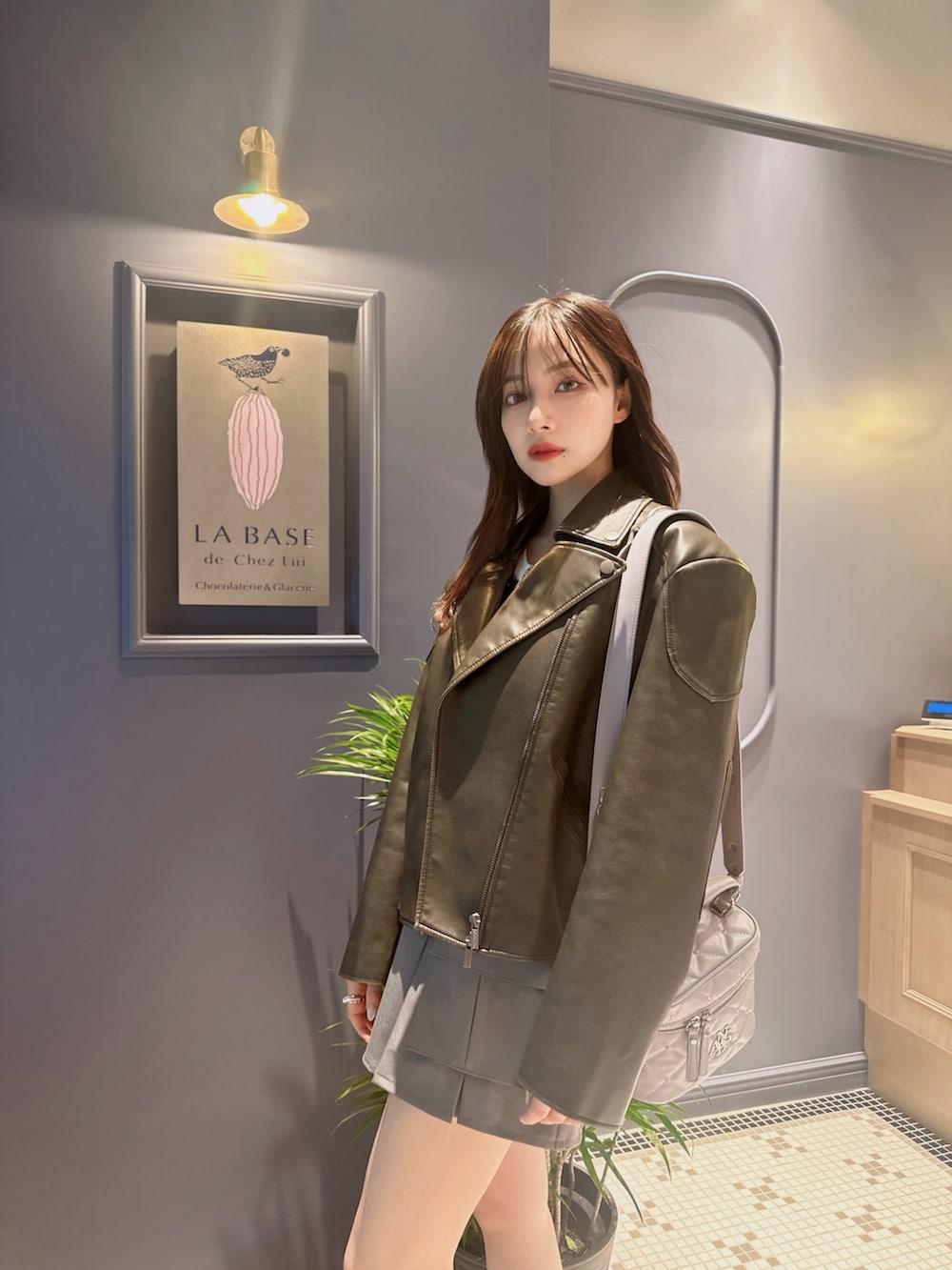 ブラック系のニット/セーター、グレー系のスカート、パープル系のショルダーバッグを着用したレディースの夏コーディネートの4枚目の写真