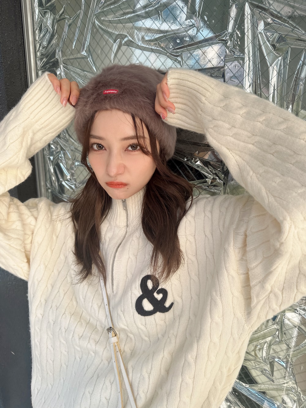 ブルー系のニット/セーター、ブルー系のパンツ、ブラウン系の帽子を着用したレディースの春コーディネートの2枚目の写真