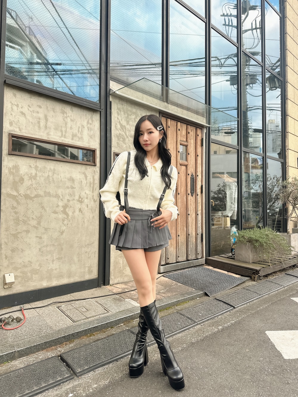 ホワイト系のニット/セーター、ブラック系のバックパック/リュックを着用したレディースの春コーディネートの2枚目の写真