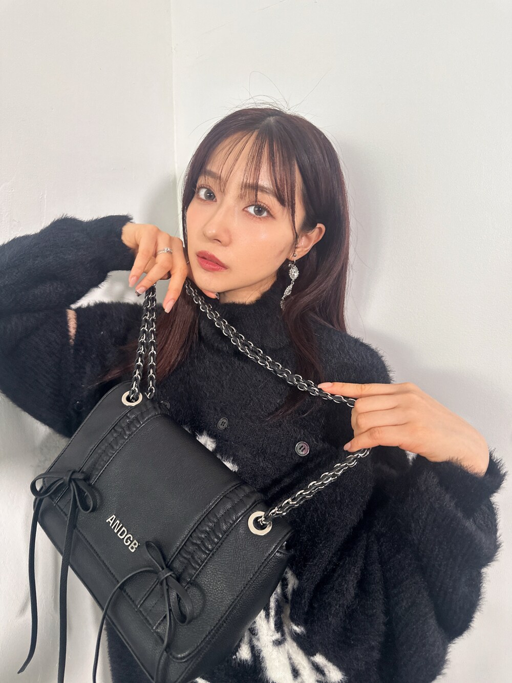 ブラック系のワンピース、ブルー系のショルダーバッグを着用したレディースの冬コーディネートの3枚目の写真