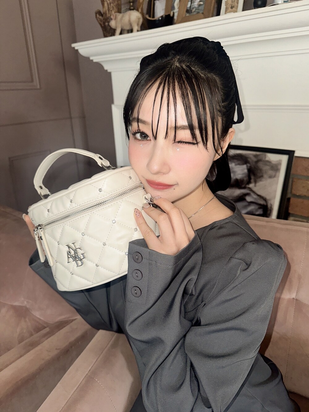 グレー系のワンピース、ホワイト系のショルダーバッグを着用したレディースの春コーディネートの4枚目の写真